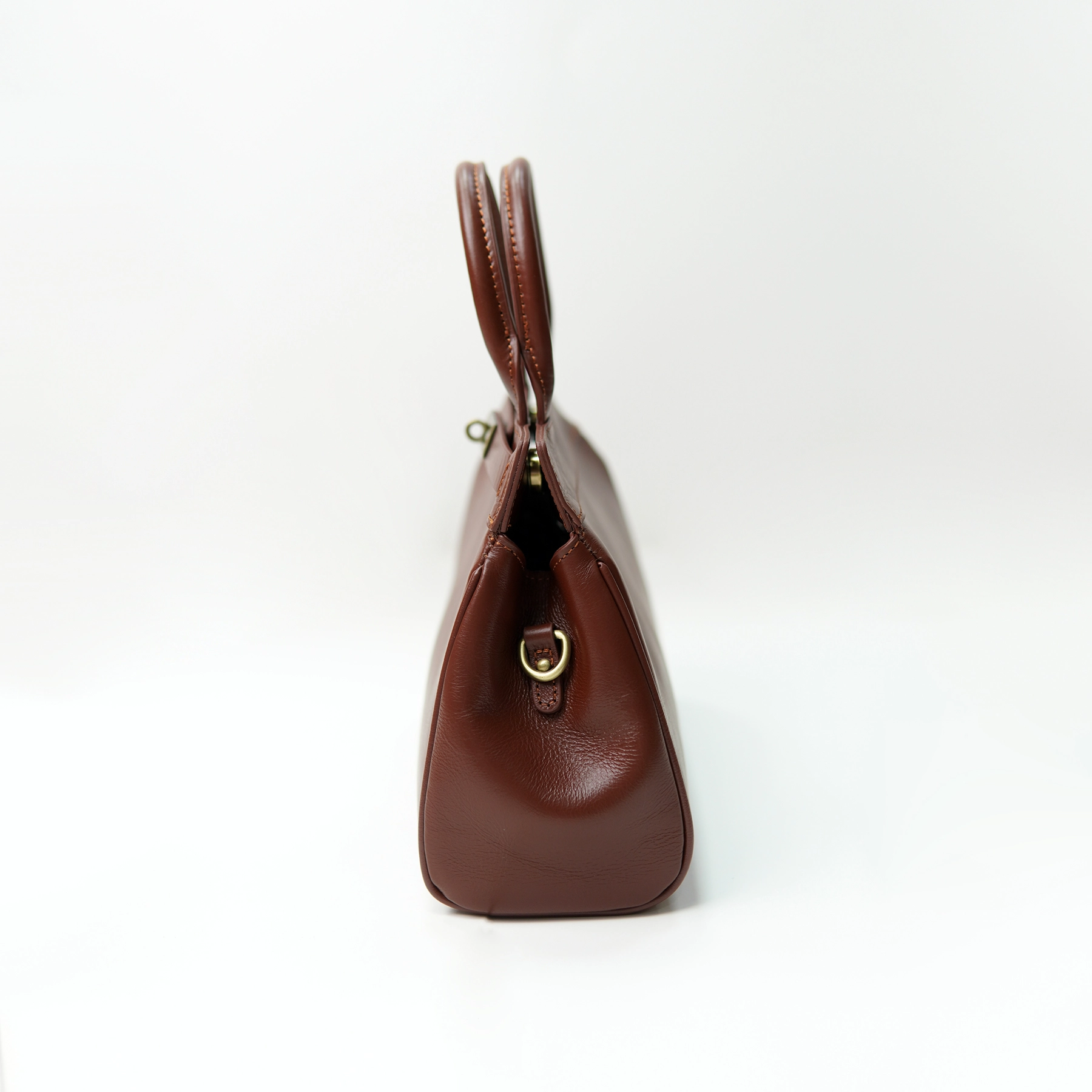 Brown leather handbag side profile for custom handbag manufacturing review
