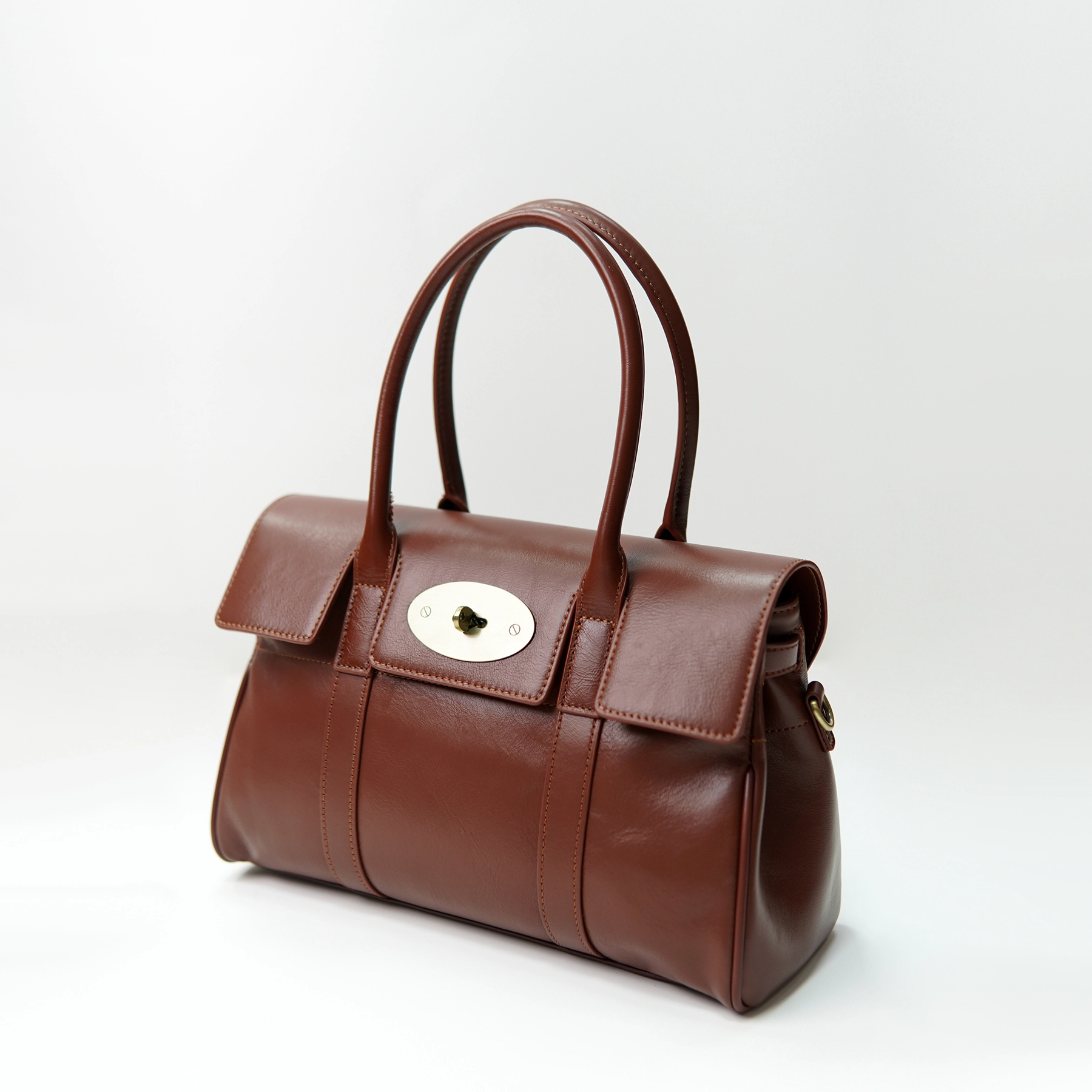 Brown leather handbag sample with flap closure for custom handbag manufacturing review