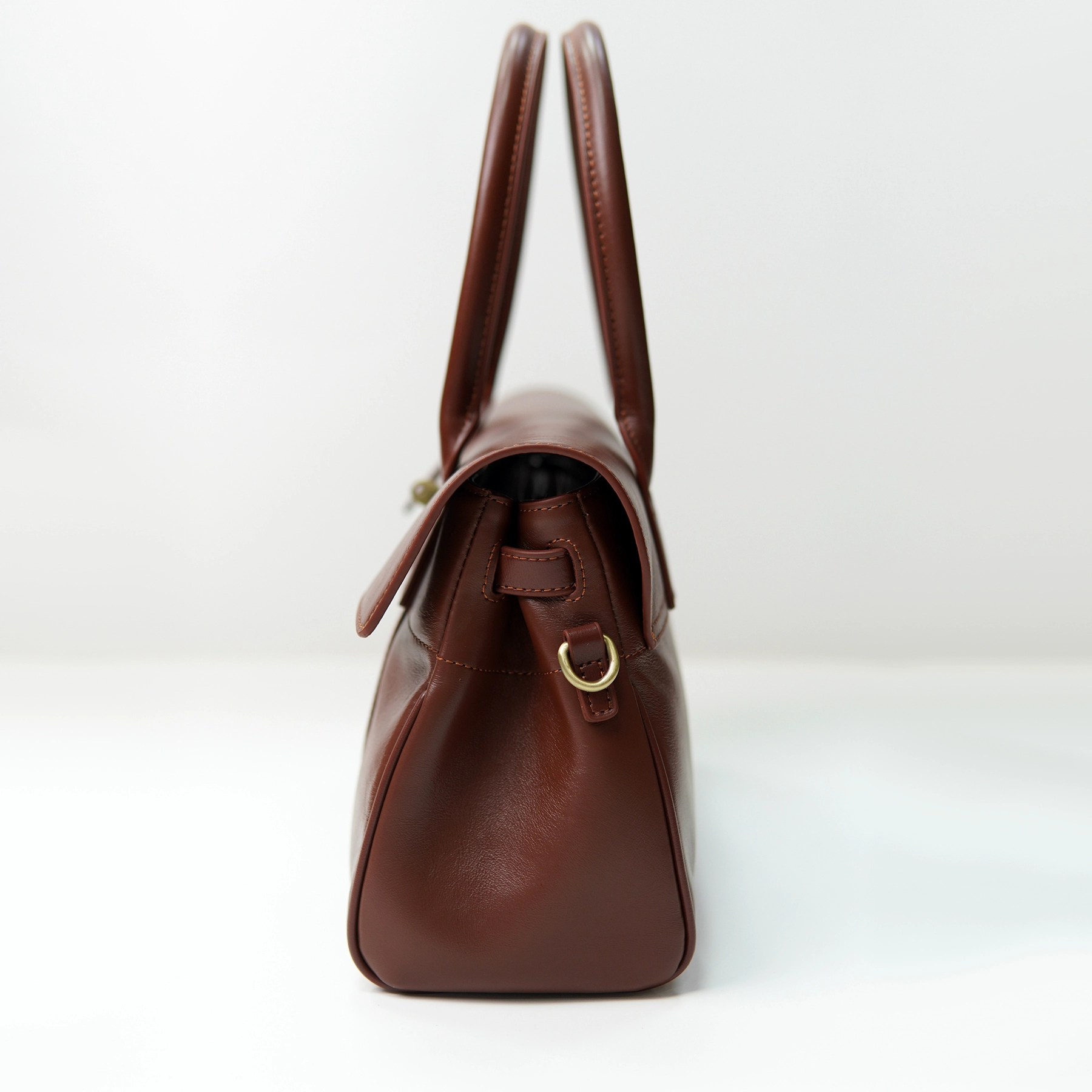Brown leather handbag side profile for custom handbag manufacturing review