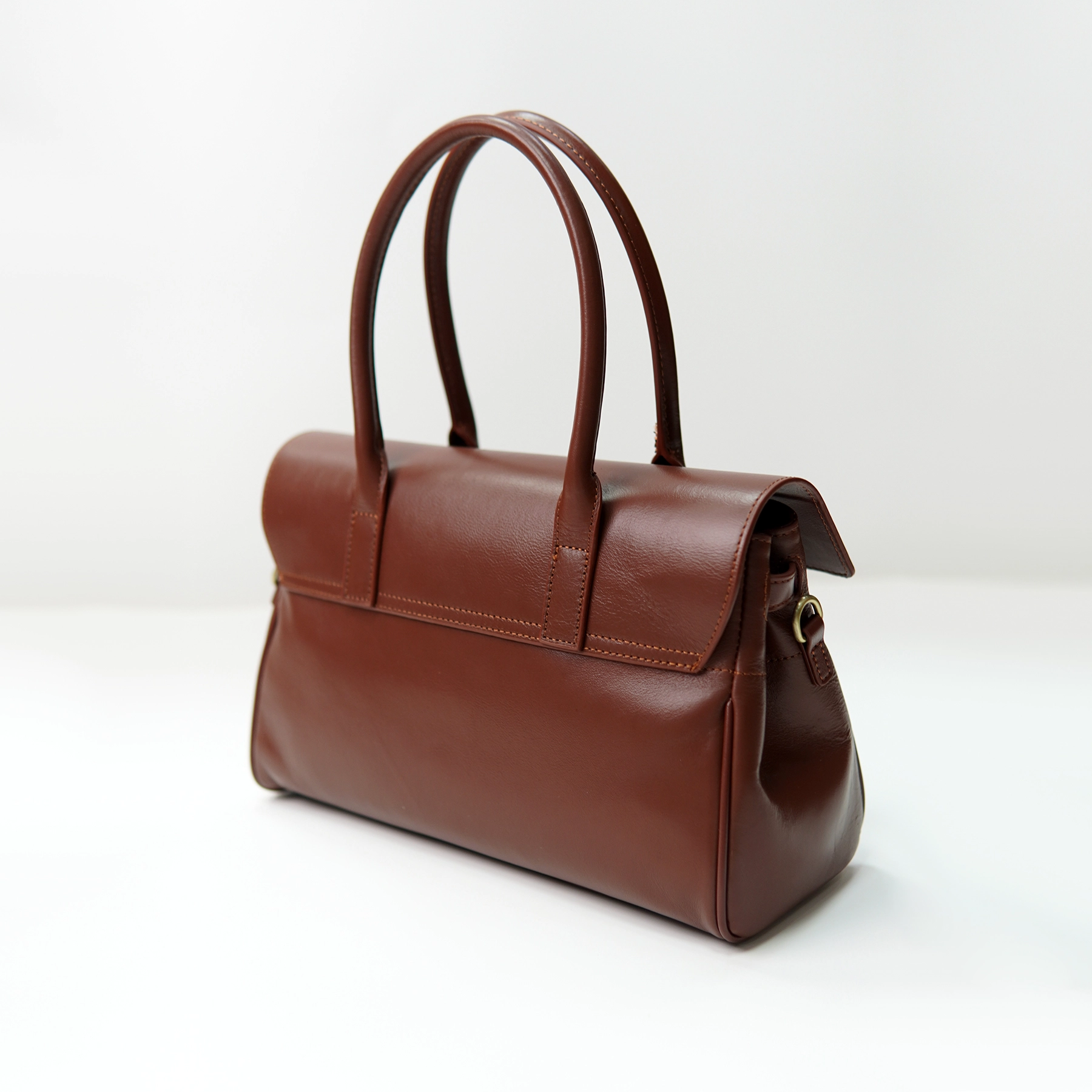 Brown leather handbag sample with dual handles for custom handbag manufacturing review
