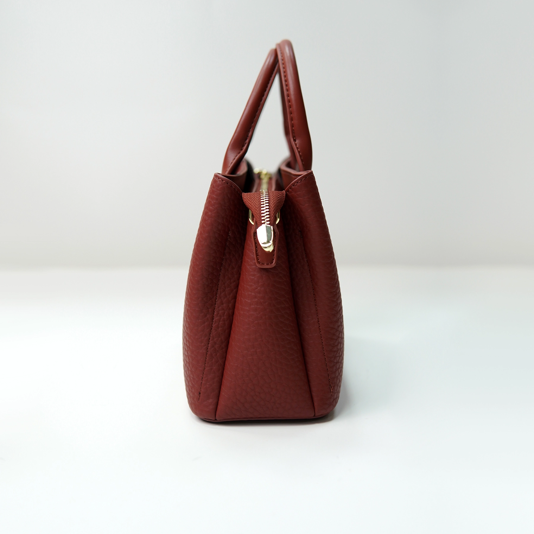 Red pebbled leather tote side profile for custom handbag manufacturing review