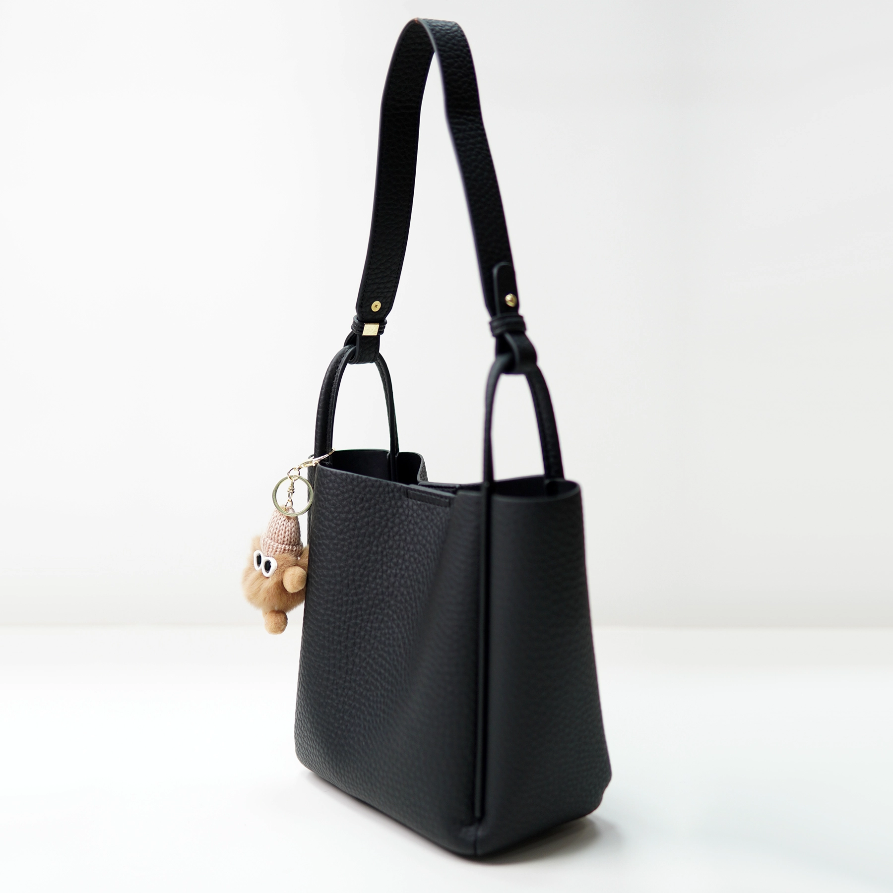 Black pebbled handbag sample with strap for custom handbag manufacturing review