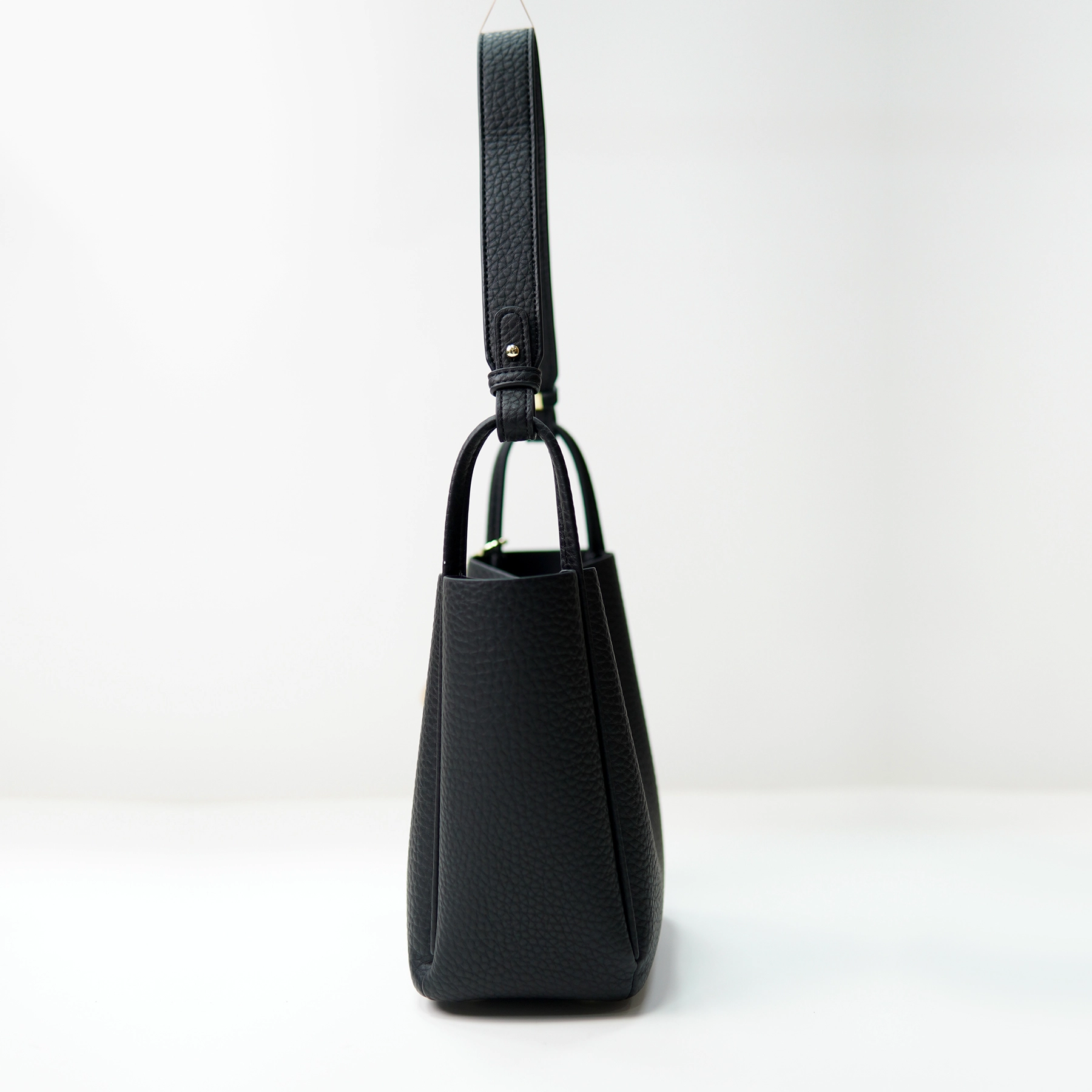 Black pebbled handbag side profile for custom handbag manufacturing review