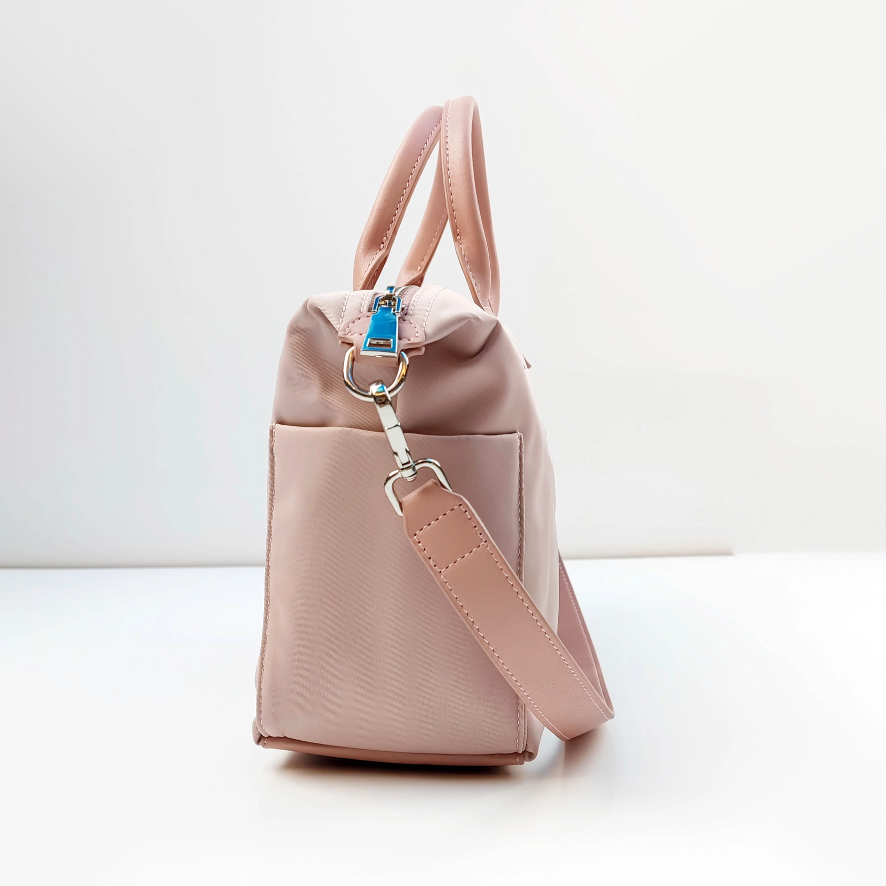 Pink handbag side profile with strap hardware for custom handbag manufacturing