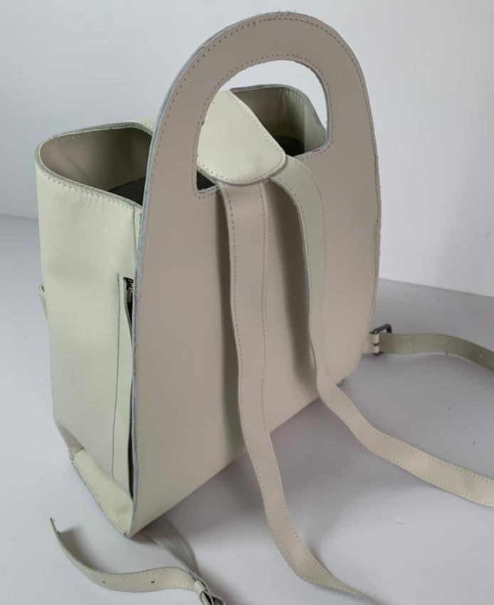Rear strap construction and triangular profile of a custom leather backpack prototype