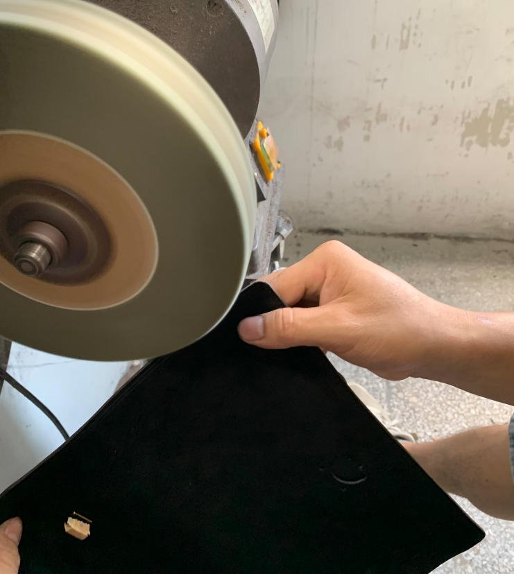 Leather Edge Sanding and Surface Preparation Leather bag component being sanded during the edge finishing process
