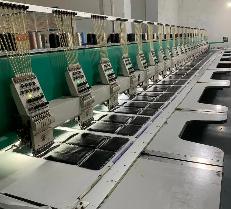 Multiple black bag panels being processed on multi-head embroidery machines